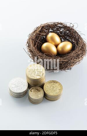 Eine vertikale Aufnahme von Goldmünzen und goldenen Eiern - Konzept Stockfoto