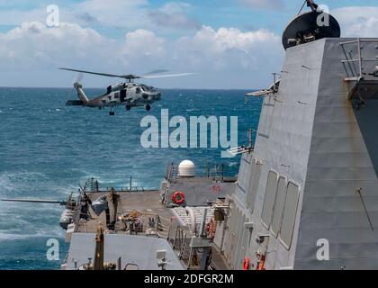 Handout-Datei Foto vom 18. August 2020 eines MH-60R Hubschraubers, der Helicopter Maritime Strike Squadron (HSM) 51 zugeordnet ist, hebt vom Flugdeck ab, während der Arleigh Burke-Klasse Lenkraketen-Zerstörer USS Mustin (DDG 89) Routineoperationen durchführt. Ein Kriegsschiff der US-Marine hat die schmale und empfindliche Taiwan-Straße zum zweiten Mal in zwei Wochen überführt. Das taiwanesische Verteidigungsministerium bestätigte die Operation am Montag inmitten steigender Spannungen zwischen China und den Vereinigten Staaten. Das Ministerium sagte, dass ein US-Zerstörer, den es nicht genannt hatte, in südlicher Richtung durch die Meerenge gesegelt war und war Stockfoto