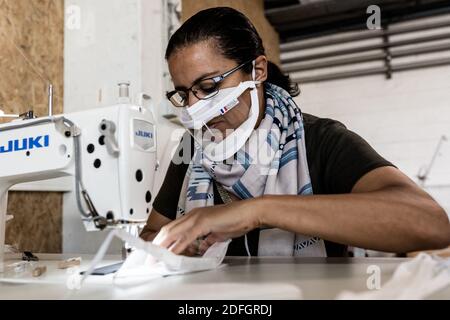 Eine Frau näht eine Masque Inclusif (inklusive Maske), eine Marke von Schutzmasken gegen die COVID19 Pandemie mit Kunststoffschutz, um Transparenz und Fähigkeit für hörgeschädigte Menschen, Lippen zu lesen, im Netzwerk von angepassten Unternehmen für behinderte Menschen zu ermöglichen. Noisy le sec, Frankreich, 22. September 2020. Stockfoto