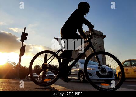 Bukarest, Rumänien - 19. Oktober 2020: Ein Radfahrer fährt mit dem Fahrrad vor dem Triumphbogen in Bukarest. Stockfoto