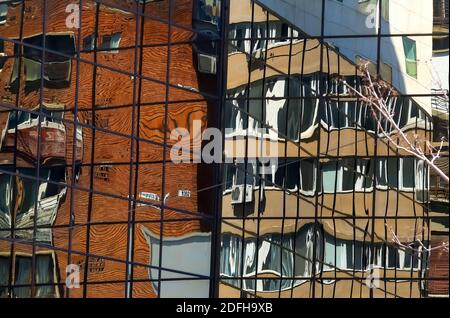 Bukarest, Rumänien - 25. März 2020 die Spiegelung eines Wohnblocks in den Fenstern eines modernen Hotelgebäudes in Bukarest. Dieses Bild ist für Stockfoto
