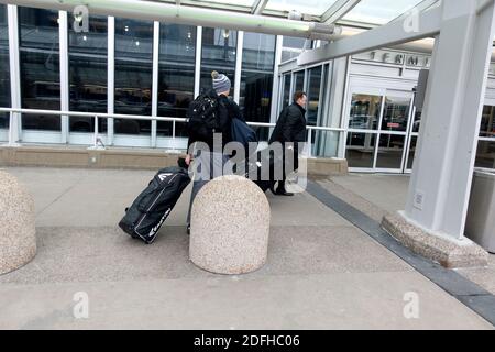 Vater und Sohn auf dem Minneapolis-Saint Paul International Airport auf dem Weg zu ihrem Flugzeug mit Gepäck. Minneapolis Minnesota, USA Stockfoto