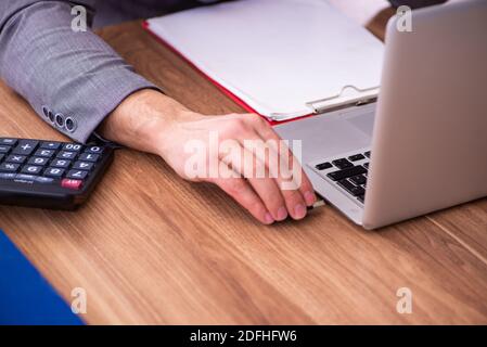 Männlicher Mitarbeiter, der Flash-Laufwerk in den Laptop einsteckt Stockfoto