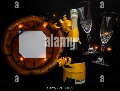 Kreative Komposition aus Stumpf und Champagner mit Papierkartonvermerk und Weihnachtslichtern. Flach liegend. Stockfoto