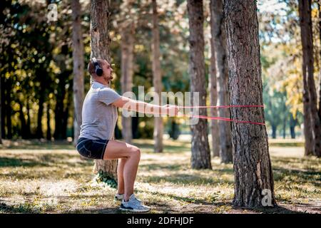Junger Mann trainiert mit Gummiband im Freien Stockfoto