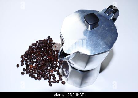 Mokakanne mit Kaffeebohnen auf weißem Hintergrund. Moka Kaffeemaschine Stockfoto