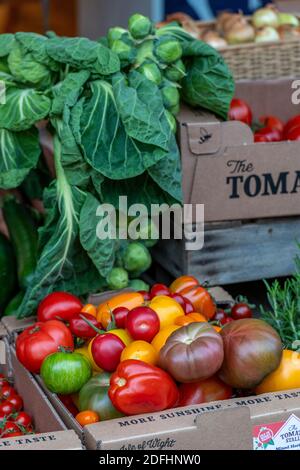 Eine Vielzahl von bunten Tomaten zum Verkauf auf einem Marktstand verkauft frisches Obst und Gemüse. Stockfoto