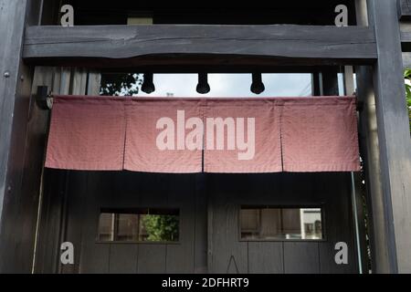 Der Vorhang-ähnliche Stoff, der vor traditionellen japanischen Restaurants und Geschäften hängt, dient nicht nur als Schild, sondern hat eine größere Bedeutung, Stockfoto