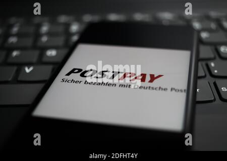 Viersen, Deutschland - 9. April. 2020: Nahaufnahme des Handybildschirms mit Logo-Schriftzug des Postpay Payment Providers auf der Computertastatur (selektiver Fokus Stockfoto