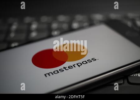 Viersen, Deutschland - 9. April. 2020: Nahaufnahme des Handybildschirms mit Logo-Schriftzug des Masterpass Payment Providers auf der Computertastatur (selektiv f Stockfoto
