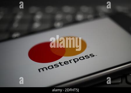 Viersen, Deutschland - 9. April. 2020: Nahaufnahme des Handybildschirms mit Logo-Schriftzug des Masterpass Payment Providers auf der Computertastatur (selektiv f Stockfoto