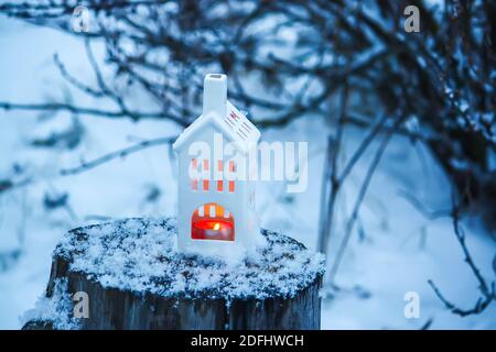 Kerzen brennen in der weißen Laterne im Wintergarten Stockfoto