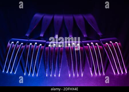 Eine Reihe von Gabeln in einem rohen mit blauen und violetten Farbverlauf führte Licht in der Dunkelheit. Stockfoto