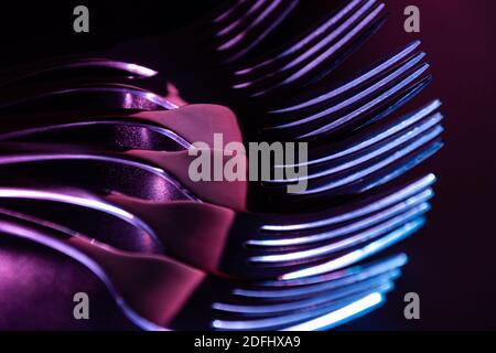 Set von Gabeln in der Dunkelheit mit blau und rot Farbverlauf LED-Licht. Stockfoto