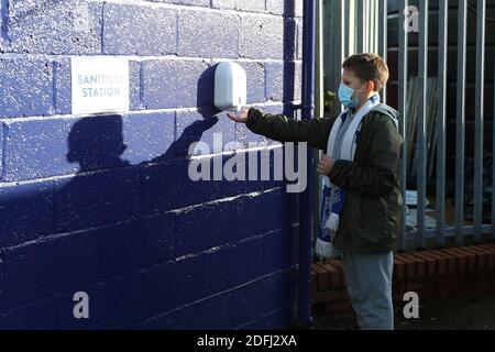 Ein junger Tranmere-Fan benutzt einen Handdesinfektionsmittel im Boden, bevor er während des Sky Bet League Two-Spiels im Prenton Park, Birkenhead, antritt. Stockfoto