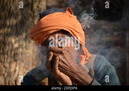 TIKAMGARH, MADHYA PRADESH, INDIEN - 03. DEZEMBER 2020: Indischer alter Mann, der chilam raucht. Stockfoto