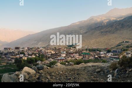 Nako Dorf durch Felder, hohe Berge des Himalaja flankiert, und felsige Spazierweg in der Spiti Valley bei Sonnenaufgang in Himachal Pradesh, Indien. Stockfoto