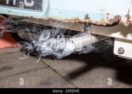 Ein rauchende Auspuffendrohr aus einem alten rostigen Auto Stockfoto