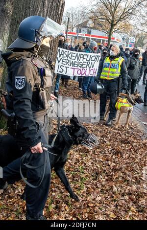 05. Dezember 2020, Bremen: Polizistinnen stehen mit Polizeihunden vor Gegendemonstratoren für die "Querdenker"-Demo, die ein Transparent mit der Aufschrift "Maske nicht tragen ist tödlich" halten. Das Bundesverfassungsgericht hat das Verbot einer geplanten "Querdenker"-Demonstration gegen die Corona-Politik bestätigt. Die niederen Instanzen hatten ihre Entscheidungen unter anderem durch die hohe Zahl der erwarteten Teilnehmer und eine Gefahr für die Öffentlichkeit gerechtfertigt. Bis zu 20,000 Teilnehmer wurden bei der Demonstration der Initiative 'Lateral Thinking 421' unter dem Motto 'Nationw Stockfoto