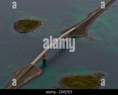 Luftaufnahme der Fredvang Straßenbrücke, die zwei Inseln Flakstadøya und Moskenesøya auf den Lofoten, Norwegen, mit felsigen Inseln und flachem Wasser verbindet. Stockfoto