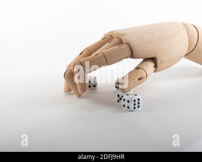 Eine hölzerne Hand über einem Würfelhaufen. Konzept auf Geld und auf Spiel. Stockfoto