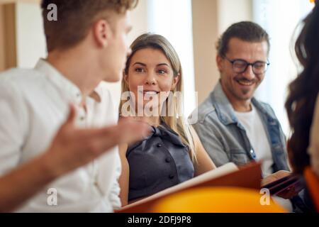 Geschäftsleute, die bei einem Meeting in einer angenehmen Atmosphäre in einem Konferenzsaal sprechen. Menschen, Arbeit, Unternehmen, Geschäftskonzept. Stockfoto