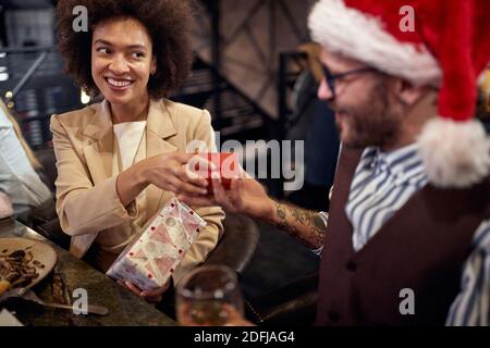 Multiethnisches Paar mit Abendessen, Austausch von Geschenken. Neujahr Feier Konzept Stockfoto