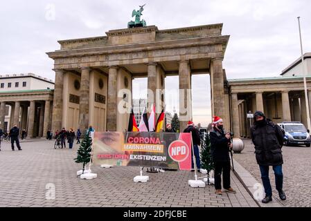 Berlin, Berlin, Deutschland. Dezember 2020. Mitglieder der Nationaldemokratischen Partei Deutschlands (NPD), einer rechtsextremen und ultranationalistischen politischen Partei in Deutschland, sind hinter einem Transparent zu sehen: "Corona-Maßnahmen zerstören Existenzen" bei einer kleinen Kundgebung vor dem Brandenburger Tor.Quelle: Jan Scheunert/ZUMA Wire/Alamy Live News Stockfoto