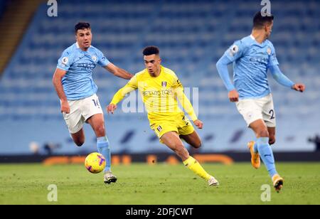 Fulhams Antonee Robinson (Mitte) kommt beim Premier League-Spiel im Etihad Stadium, Manchester, an Rodrigo Hernandez Rodri von Manchester City vorbei. Stockfoto