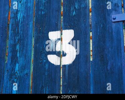 Nummer drei auf einem alten verlassenen verwitterten blauen Farbe Holztor in Budapest Vorort, Ungarn Stockfoto