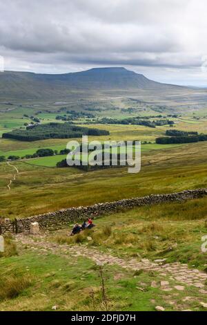 Ingleborough (Berg oder Hügel), eine Reihe von Hügeln, Menschen sitzen mit Blick auf die malerische Landschaft Dales - Ribble Valley, Yorkshire, England, Großbritannien. Stockfoto