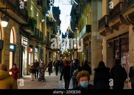 barcelona, spanien - 3. dezember 2020: weihnachtszeit in barcelona. Menschen gehen in der Innenstadt in der Nacht tun weihnachtseinkäufe mit weihnachtslicht Stockfoto