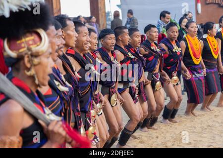 Eine Gruppe von Naga Tribesmen und Frauen in ihren gekleidet Traditionelle Kleidung Tanz während Hornbill Festival in Nagaland Indien auf Dezember 2016 Stockfoto