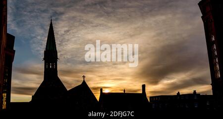 Panoramabild eines Sonnenaufgangs über der Harrow School mit Silhouette der Harrow School Chapel und Vaughan Library, England Stockfoto