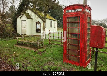 Alte Telefonbox und kleine Wellblech-Dorfhalle in Stainton Le Vale, Lincolnshire, Großbritannien. Stockfoto