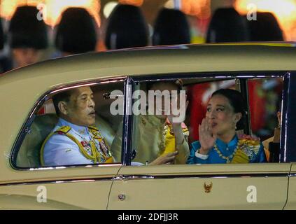 Thailands König Maha Vajiralongkorn, Königin Suthida und Prinzessin Bajrakitiyabha (R) verlassen nach einer Kerzenlicht-Mahnwache, um an den Geburtstag des verstorbenen Königs Bhumibol Adulyadej in Thailand vor dem Großen Palast in Bangkok zu erinnern. Stockfoto