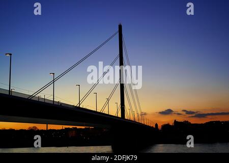 Oberkasseler Brücke im Sonnenuntergang. Die Kabelbrücke verbindet die Stadt mit dem Stadtteil Oberkassel. Stockfoto