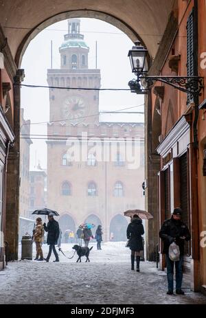 Schnee fällt in der Via Clavature mit Blick durch den Bogen zum Palazzo Comunale auf der Piazza Maggiore, Bologna, Italien Stockfoto