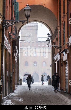 Schnee fällt in der Via Clavature mit Blick durch den Bogen zum Palazzo Comunale auf der Piazza Maggiore, Bologna, Italien Stockfoto