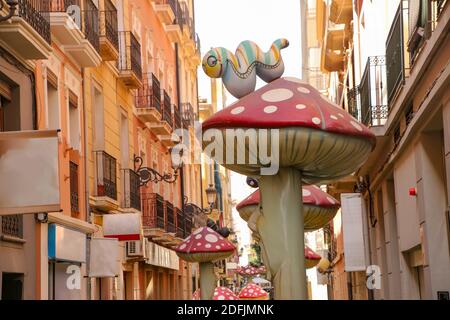 Calle de Las Setas, Straße der Pilze. Schmale Straße mit großen Statuen von Cartoon-Pilze. Alicante Altstadt, Costa Blanca, Spanien. Stockfoto