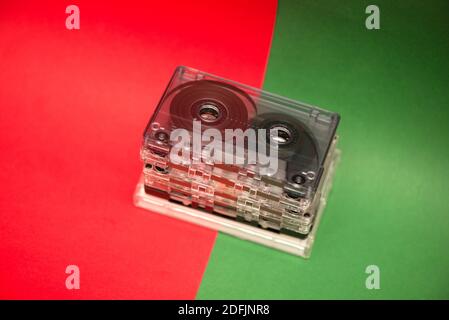 Ein Stapel von Audio-Kassetten aus Kunststoff auf rot und Grüner Hintergrund Stockfoto