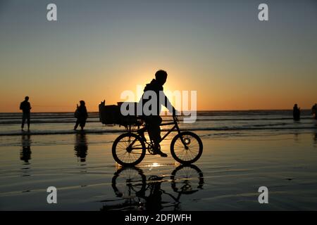 Karatschi. Dezember 2020. Das am 4. Dezember 2020 aufgenommene Foto zeigt die Silhouette eines Jungen, der am Strand während des Sonnenuntergangs in der südpakistanischen Hafenstadt Karachi Fahrrad fährt. Quelle: Ahmad Kamal/Xinhua/Alamy Live News Stockfoto