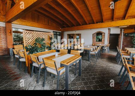 Ein Restaurant im Freien mit Holzstühlen und -Tischen Stockfoto
