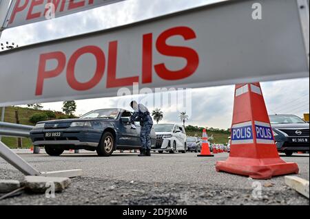 Selangor, Malaysia. Dezember 2020. Ein Soldat überprüft ein Fahrzeug an einem Kontrollpunkt auf einer Autobahn in Setia Alam im Bundesstaat Selangor, Malaysia, 5. Dezember 2020. Die malaysische Regierung sagte am Samstag, dass sie die Bewegungskontrollordnung in mehreren Bereichen bis zum 20. Dezember verlängern wird, um die Ausbreitung von COVID-19 zu kontrollieren. Am Samstag meldete das malaysische Gesundheitsministerium 1,123 neue bestätigte COVID-19 Fälle, womit die nationale Gesamtzahl auf 71,359 angesetzt wurde. Quelle: Chong Voon Chung/Xinhua/Alamy Live News Stockfoto