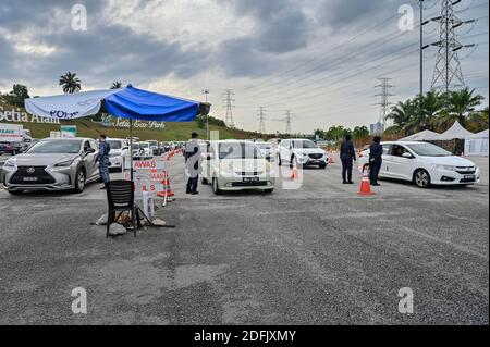 Selangor, Malaysia. Dezember 2020. Polizeibeamte und ein Soldat überprüfen Fahrzeuge an einem Kontrollpunkt auf einer Autobahn in Setia Alam des Staates Selangor, Malaysia, 5. Dezember 2020. Die malaysische Regierung sagte am Samstag, dass sie die Bewegungskontrollordnung in mehreren Bereichen bis zum 20. Dezember verlängern wird, um die Ausbreitung von COVID-19 zu kontrollieren. Am Samstag meldete das malaysische Gesundheitsministerium 1,123 neue bestätigte COVID-19 Fälle, womit die nationale Gesamtzahl auf 71,359 angesetzt wurde. Quelle: Chong Voon Chung/Xinhua/Alamy Live News Stockfoto