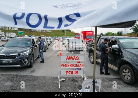 Selangor, Malaysia. Dezember 2020. Ein Polizist und ein Soldat überprüfen Fahrzeuge an einem Kontrollpunkt auf einer Autobahn in Setia Alam des Staates Selangor, Malaysia, 5. Dezember 2020. Die malaysische Regierung sagte am Samstag, dass sie die Bewegungskontrollordnung in mehreren Bereichen bis zum 20. Dezember verlängern wird, um die Ausbreitung von COVID-19 zu kontrollieren. Am Samstag meldete das malaysische Gesundheitsministerium 1,123 neue bestätigte COVID-19 Fälle, womit die nationale Gesamtzahl auf 71,359 angesetzt wurde. Quelle: Zhu Wei/Xinhua/Alamy Live News Stockfoto