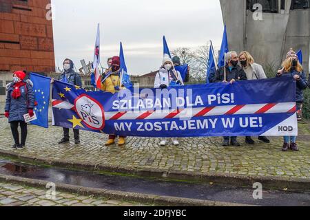 Danzig, Polen. Dezember 2020. Demonstranten mit Gesichtsmaske wegen der Einschränkungen des Coronavirus, mit Flaggen der Europäischen Union und Polens und einem Banner mit der Aufschrift Wir bleiben in der EU, STOPP von Recht und Gerechtigkeit (PiS) werden am 5. Dezember 2020 in Danzig, Polen, zu sehen sein.Menschen protestieren gegen das Veto der polnischen Regierung gegen den EU-Haushalt. Sie sagen, dass das Veto ein so genannter Polexit (Verlassen der EU durch t Polen) erster Schritt ist. Quelle: Vadim Pacajev/Alamy Live News Stockfoto