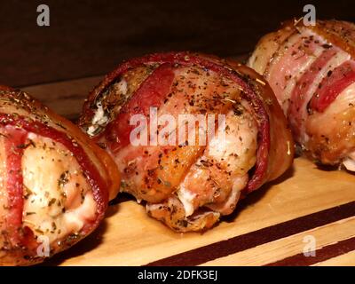 Frisch aus dem Ofen gefüllte Hähnchenschenkel in Speck eingewickelt Stockfoto