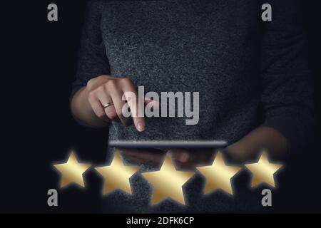 Kundenerfahrung. Service-Bewertung und -Überprüfung. Bewertungsumfrage. Fünf Sterne Formen vor dem Hintergrund einer Frau, die online eine Bewertung auf einem Stockfoto