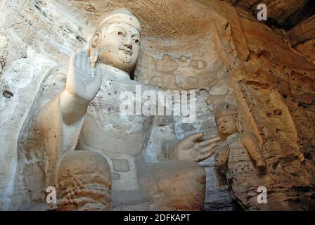 Yungang Grotten in der Nähe von Datong in der Provinz Shanxi, China. Große alte Statue von Buddha in einer Höhle bei Yungang. Landschaftsansicht von der Seite Stockfoto